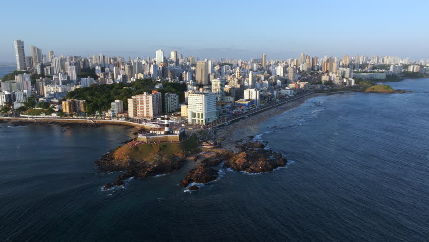 Aerial view of Salvador cityscape with the historic Barra lighthouse, the oldest lighthouse in operation on the coast of the Americas, at sunset in Salvador, Bahia, Brazil. 
