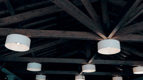 circular ceiling lamps glowing against exposed wooden beams in dim space - Powered by Shutterstock - Get 15% off with code: PIKWIZARD15