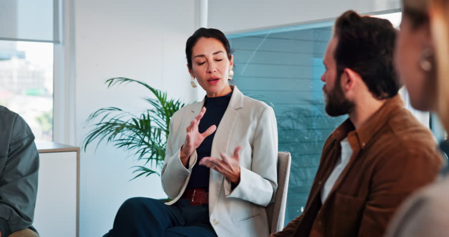 Woman, talking and group of people with therapist for counseling, help and recovery advice. Psychologist, explaining and discussion with community, support and awareness for healing of mental health