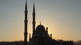 Golden sunrise illuminates a mosque's silhouette, highlighting its elegant architecture against a tranquil sky - Powered by Shutterstock - Get 15% off with code: PIKWIZARD15
