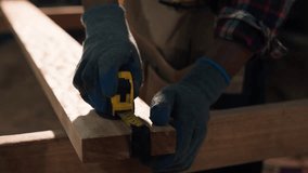Young African American carpenter measuring and marking wood with tape and pencil inside a timber workshop, highlighting craftsmanship, precision, and manual woodworking skills. - Powered by Shutterstock - Get 15% off with code: PIKWIZARD15