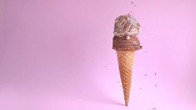 summer funny creative concept of standing wafer cone with chocolate and chocolate chips scoops of ice cream decorated with strewed sprinkles on pink background, copy space, super slow motion - Powered by Shutterstock - Get 15% off with code: PIKWIZARD15