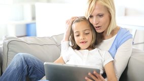 Mother and daughter playing with electronic tablet