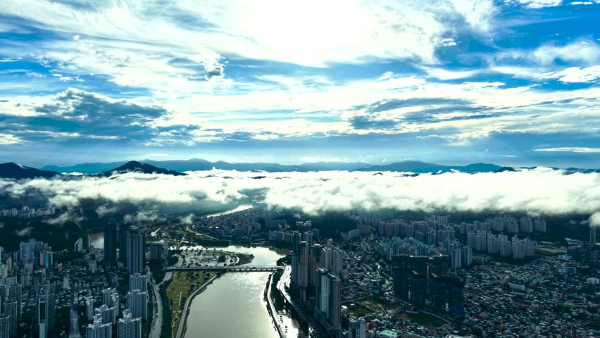 experience a breathtaking aerial view of the city skyline above the clouds. watch as the skyscrapers pierce through the fog, creating a stunning cityscape. enjoy the scenic mountain range 200
