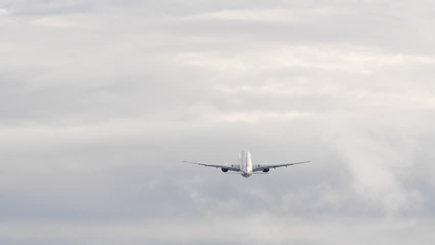 Slow motion scene of a passenger aircraft lifting off, takeoff. The plane ascends steadily