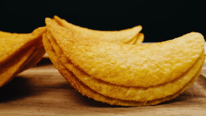 Crispy potato chips close up pack in macro. Golden fried potatoes close up. Potato snack for unhealthy fast food. 