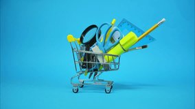 Yellow shopping cart filled with school supplies moves on blue background. Stop motion animation  - Powered by Shutterstock - Get 15% off with code: PIKWIZARD15