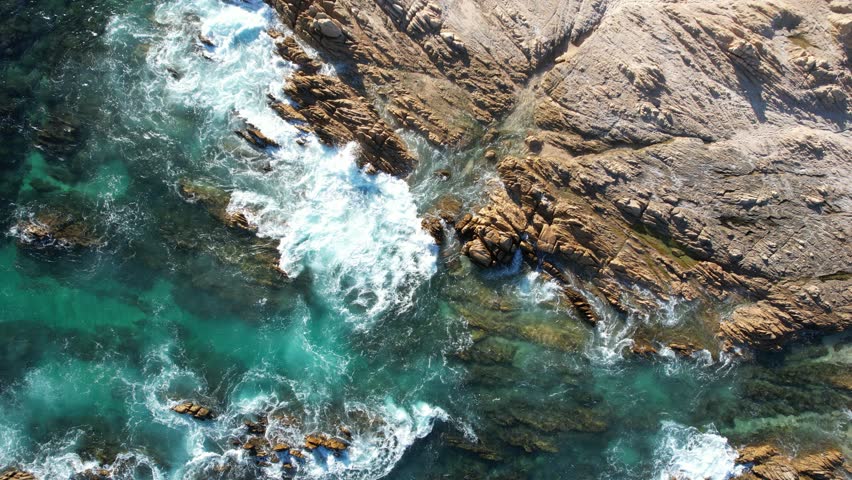 Drone flight over the beach with waves breaking on the shore in Baja California Sur, Mexico.
