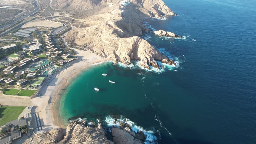 Drone flight over the beach with waves breaking on the shore in Baja California Sur, Mexico.