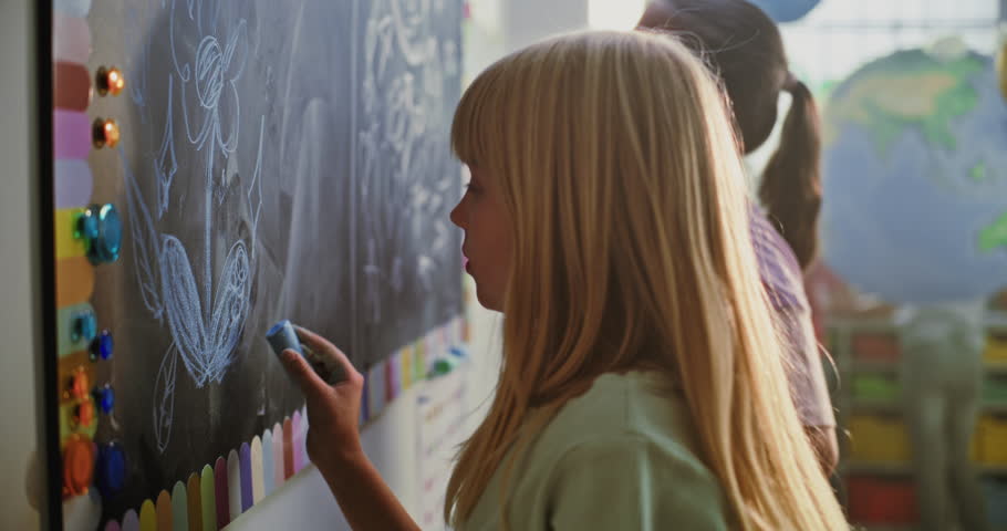 Happy Elementary School Students Drawing on Chalkboard, Enjoying Creative and Interactive Activity in Modern Classroom. Kids Having Fun, Developing Imagination and Collaboration Skills. Slow Motion.