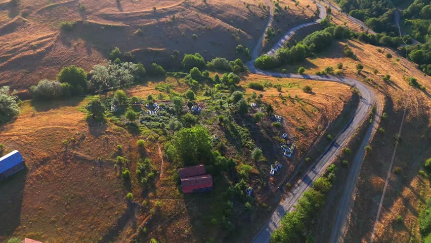 A peaceful aerial view of the hillside cemetery in Kurtlu Village, Boyabat, Sinop. Surrounded by golden fields and winding roads, this resting place reflects the quiet beauty rural Turkey Turkiye 4k