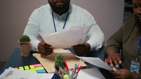 Close up of diverse staff collaborating on data forecasting and analysis, exchanging documents late in the office. Updating stakeholders with predictions and other business intel. Camera A. - Powered by Shutterstock - Get 15% off with code: PIKWIZARD15