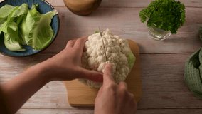 Woman cutting white cauliflower cabbage in halves, cooking vegetables - Powered by Shutterstock - Get 15% off with code: PIKWIZARD15