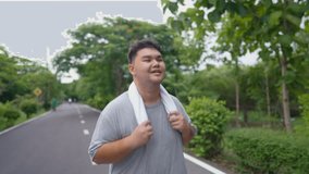 Asian plus-size man exercises outdoors in the garden to lose weight. Attractive young overweight guy spend leisure time on weekend doing running workout to improve health and overall fitness in park. - Powered by Shutterstock - Get 15% off with code: PIKWIZARD15