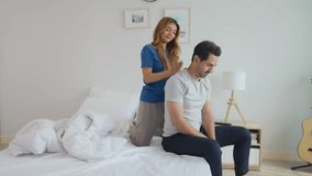 Caucasian husband getting back massage treatment from his wife at home. Attractive new marriage man and woman spouse lying down on bed, spending free leisure time together in bedroom at home. - Powered by Shutterstock - Get 15% off with code: PIKWIZARD15