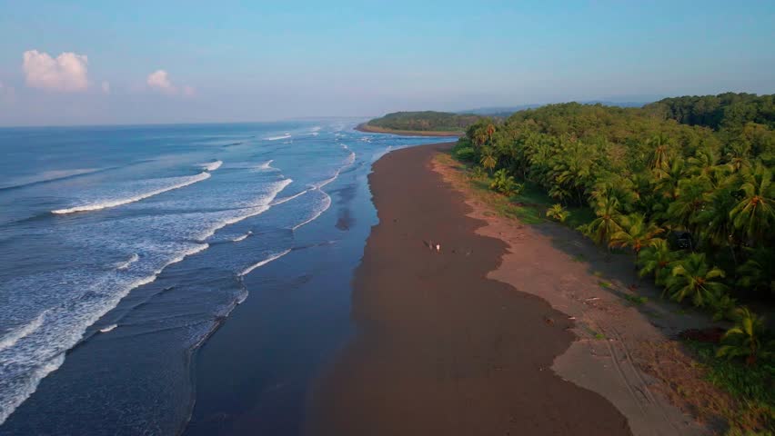 Aerial reverse shot of tropical beach and ocean waves, Costa Rica