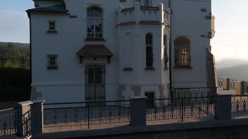 Elegant white building with red copper details filmed with an ascending drone in the city of Decin, Czech Republic.