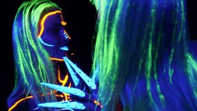 Portrait of a young girl on a dark background painted with fluorescent colors. A woman with glowing makeup poses for the camera. - Powered by Shutterstock - Get 15% off with code: PIKWIZARD15