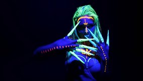Portrait of a young girl on a dark background painted with fluorescent colors. A woman with glowing makeup poses for the camera. - Powered by Shutterstock - Get 15% off with code: PIKWIZARD15