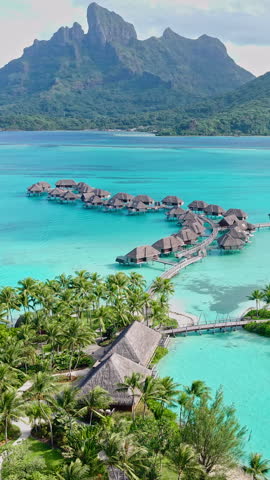 Bora Bora, French Polynesia. Luxury Resort and Overwater Bungalows Overlooking Lagoon and Main Island, Vertical Drone Shot