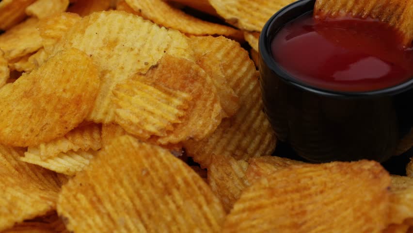 Potato chips with tomato sauces close-up