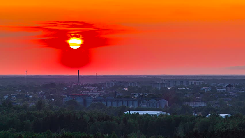 Moonlight Setting Against Red Sky Over City And Industrial Facility. Timelapse