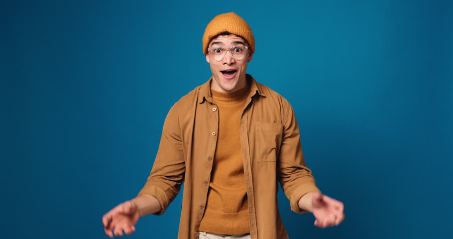 Man, face and excited with surprise in studio, announcement or mock up space on blue background. Person, wow and portrait with mind blown for shock, giveaway or win prize with competition in Mexico