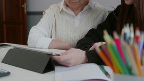 Elderly grandmother providing patient guidance to young granddaughter while navigating digital tablet, sharing knowledge and strengthening family bond through technological learning - Powered by Shutterstock - Get 15% off with code: PIKWIZARD15