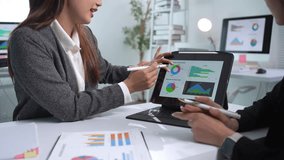 Two businesswomen discussing data analysis while collaborating on a digital tablet in a modern office setting - Powered by Shutterstock - Get 15% off with code: PIKWIZARD15