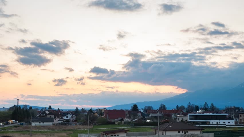 4K Timelapse of sunset over Poprad, Slovakia, from train station viewpoint. Scenic rooftops, pastel sky, and distant mountains—ideal for travel, landscape, and urban footage.