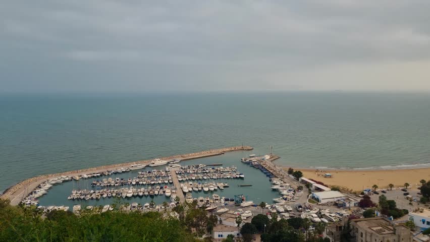 Panoramic view of the marina and beach of Sidi Bou Said near Tunis, Tunisia, with the Mediterranean Sea stretching to the horizon on an overcast spring day
