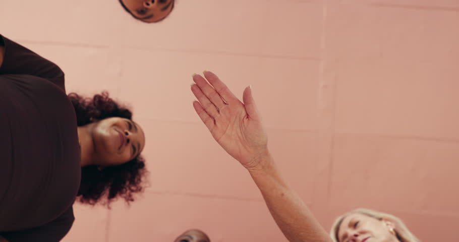 Huddle, motivation and stack of hands with women in studio together for health, wellness or yoga from below. Fitness, palm and solidarity with group of friends in circle for support or team building