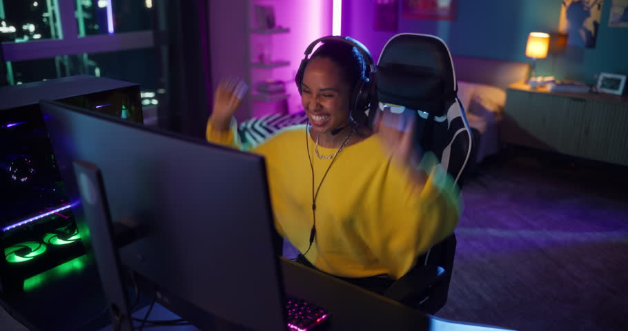 Female Immersed in a Competitive Online Video Game at Her Home Setup in a Neon-lit Room. Black Gamer Winning a Match in a 3D Shooter Tournament. Swirling Robotic Camera Footage