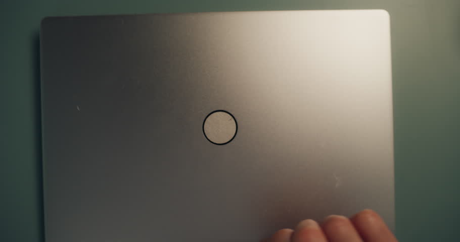 Close Up of a Young Multiethnic Man Opening Up a Laptop and Starting to Work at Home. Male Sitting Behind a Table in Living Room, Using Computer. Dynamic Robot Camera Footage