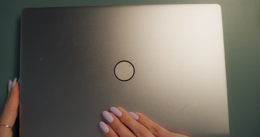 Young Caucasian Female Opening Up a Laptop and Starting to Work at Home. Woman Sitting Behind a Table in Living Room, Using Computer. Dynamic Close Up Portrait Made with a Robotic Camera Arm