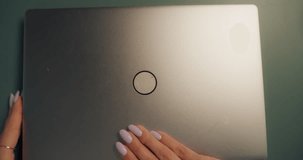 Young Caucasian Female Opening Up a Laptop and Starting to Work at Home. Woman Sitting Behind a Table in Living Room, Using Computer. Dynamic Close Up Portrait Made with a Robotic Camera Arm - Powered by Shutterstock - Get 15% off with code: PIKWIZARD15