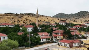 A traditional village mosque stands tall among red-roofed houses. countryside scene. rural houses. - Powered by Shutterstock - Get 15% off with code: PIKWIZARD15