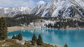 Beautiful mountain lake reflects snow-covered peaks and lush evergreen trees, creating a serene natural landscape with vibrant colors - Powered by Shutterstock - Get 15% off with code: PIKWIZARD15