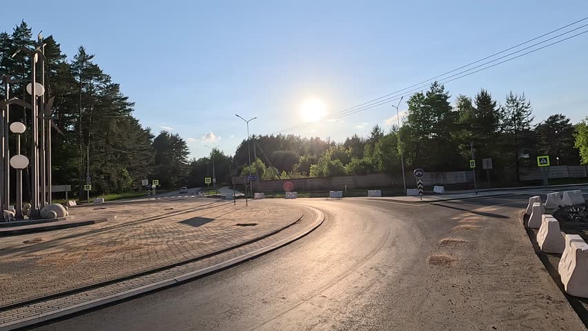 Roadside and road on a sunny day. View of the landscape and rays of the sun.