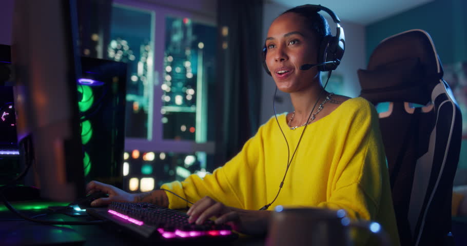 Excited Female Playing a Video Game with Lots of Action, Communicating with Online Teammates Through the Headphones with Mic. Gamer Playing in a Stylish Neon Room. Slow Motion Footage