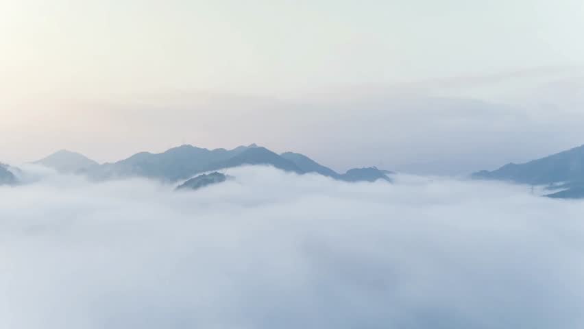 Misty mountain range landscape with fog and clouds in a serene atmosphere