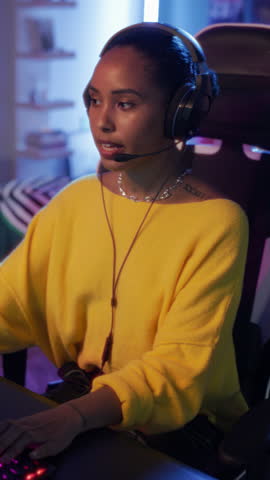 Vertical Screen: Female Gamer Playing Online Video Game on Computer. Portrait of a Black Gamer in Headphones Battling in Shooter Tournament and Celebrating the Win. Filmed with Cinematic Robot Arm