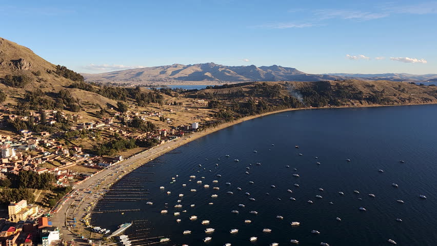 Experience a breathtaking pan shot of the incredible city of Copacabana, Bolivia, during sunset. The vibrant evening sky over Lake Titicaca.