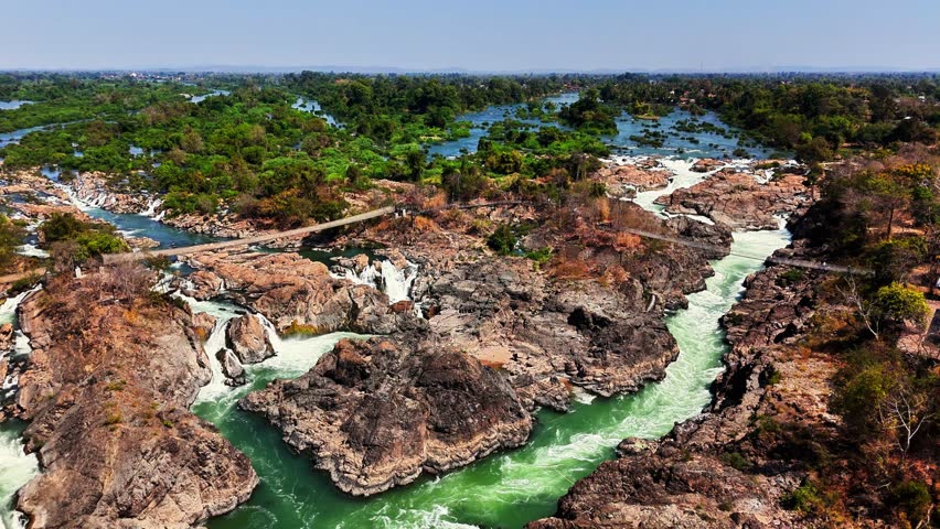 Aerial shot of Mekong River carving through rocky terrain near Don Det in the Si Phan Don - Four Thousand Islands region of southern Laos, with rapids and channels weave through lush tropical wetlands