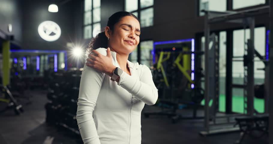 Fitness, woman and shoulder pain in gym, massage or hurt with training accident, sore and fractured. Injury, person and muscle strain in health club, discomfort and joint tension or broken bone