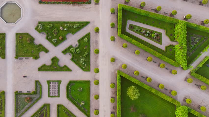 Top down view reveals French garden symmetry and gravel paths in golden light