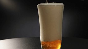 Super slow motion close-up of beer, alcohol, and carbonated drink beverage and ale brew pouring and spilling into a glass and over pouring out of container, with bubbles and carbonation in a studio 4k - Powered by Shutterstock - Get 15% off with code: PIKWIZARD15