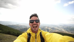 Young hiker man taking selfie portrait on the top of mountain - Happy guy smiling at camera - Hiking, sport, travel and technology concept - Bright filter - 4k video - Powered by Shutterstock - Get 15% off with code: PIKWIZARD15