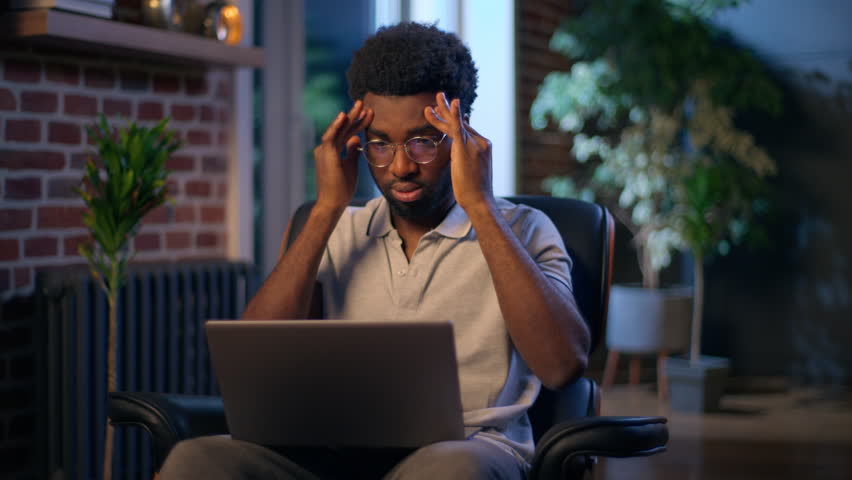 African American business man headache businessman tired worker typing laptop in night evening office late online work overtime busy deadline computer stress exhausted overwork employee problem health