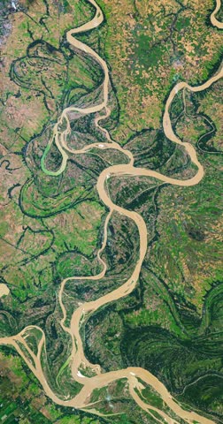 Aerial perspective on meanders of river in agricultural region with many parcels of land. Camera is zooming in, rotating clockwise. Vertical video. Animation based on image by NASA